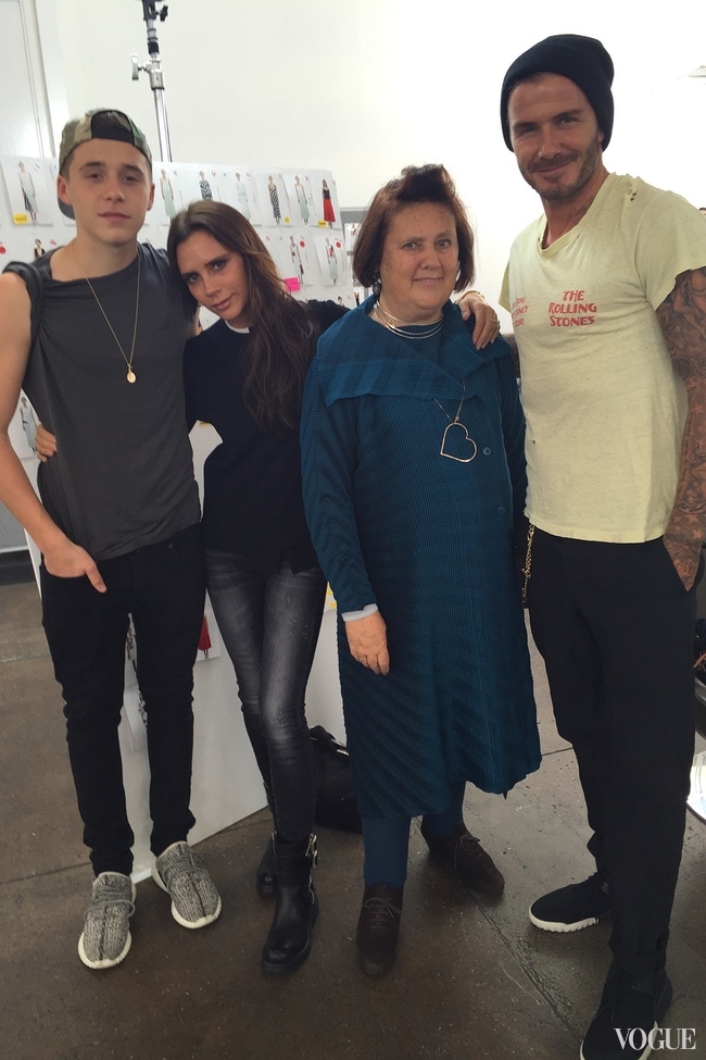 Suzy with David, Victoria and Brooklyn Beckham with images from the spring summer 2016 collection in the background